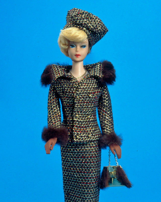 Barbie doll in a dark moody setting illustrating the iconic 1961 bubble cut hairstyle